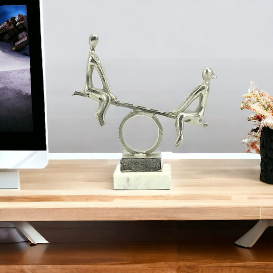 Silver Aluminum Couple on Seesaw Sculpture: Handcrafted Art on White Marble Base
